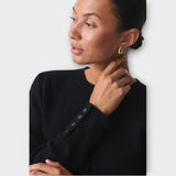 Moderna kratka jopica z gumbi in elegantnimi podrobnostmi